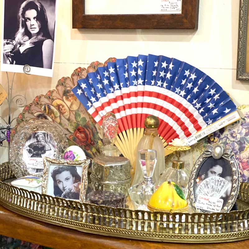 Vintage photo frames and dressing table items with US Flag paper flag in background