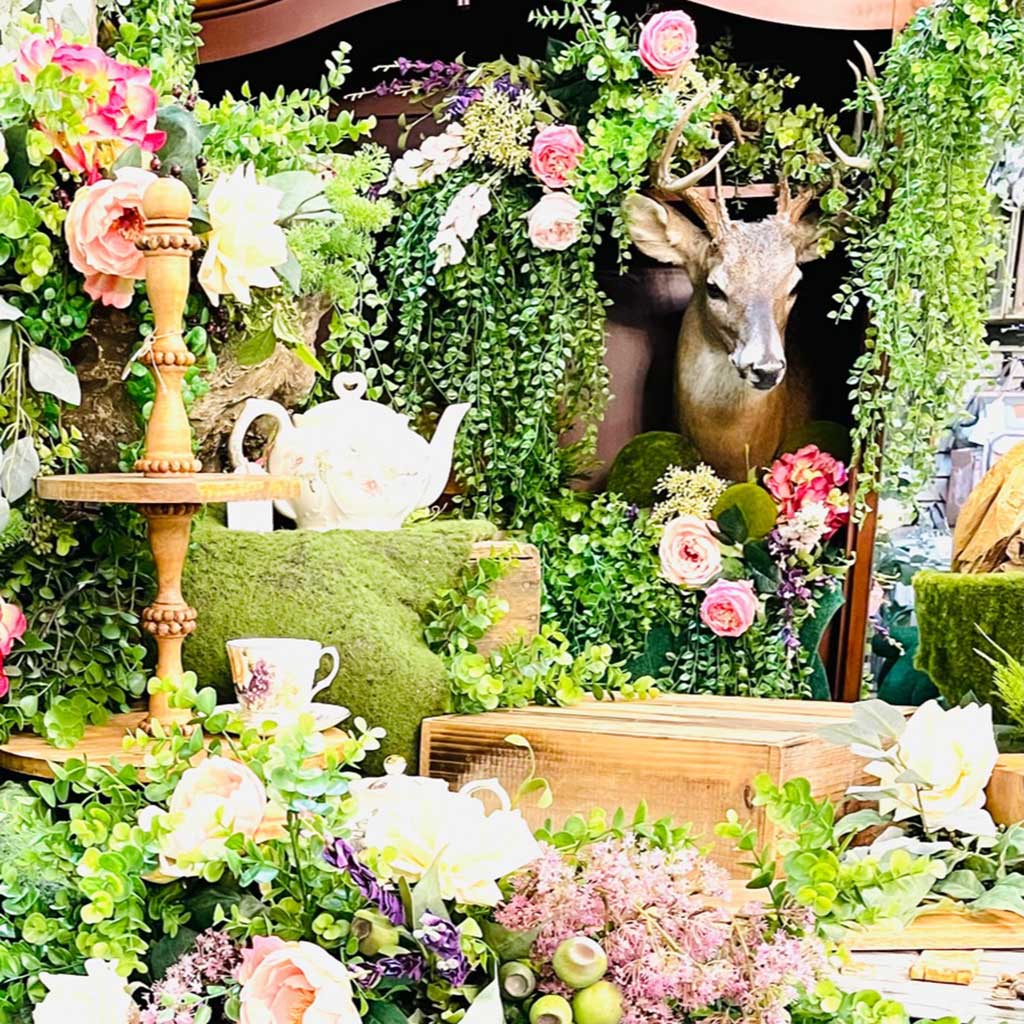 Floral design with deer head peeking through with tea pot and cups