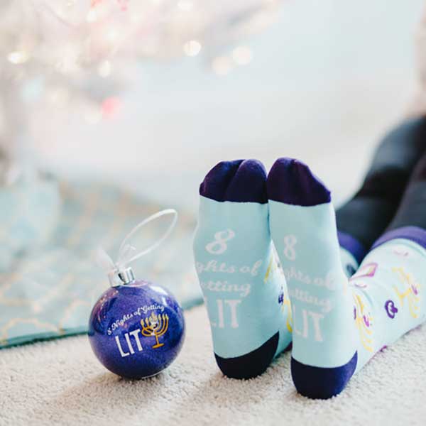 8 Nights Getting Lit socks and Hanukkah ornament girl wearing socks