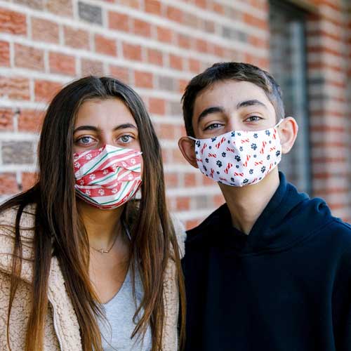 Holiday Paws Kid&#39;s Face Mask disposable with paw prints on red ribbon siblings wearing masks