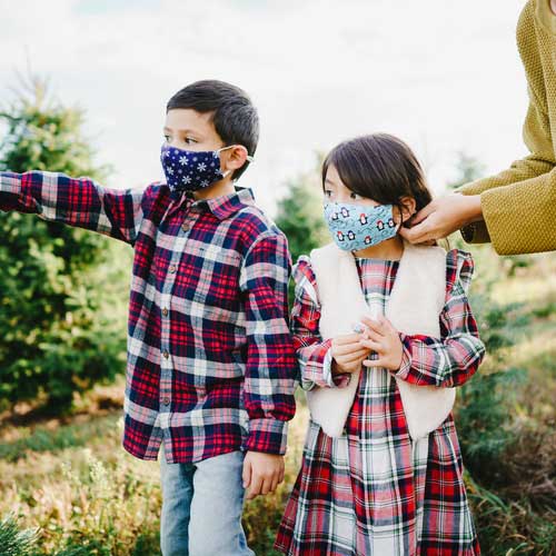 Snowflakes kid&#39;s face mask with snwoflakes on blue background children outdoors