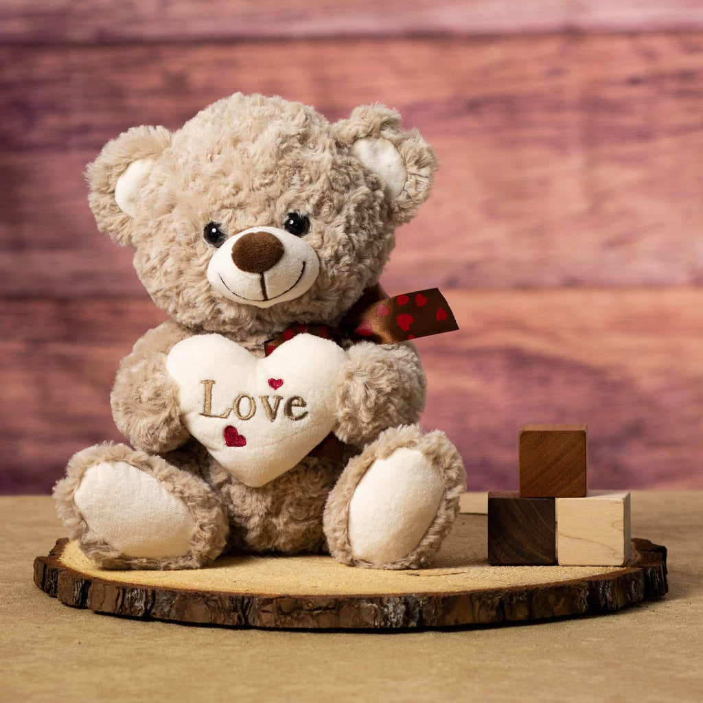 Plush Valentine Bear holding a plush cream-colored heart inscribed with &quot;Love&quot;